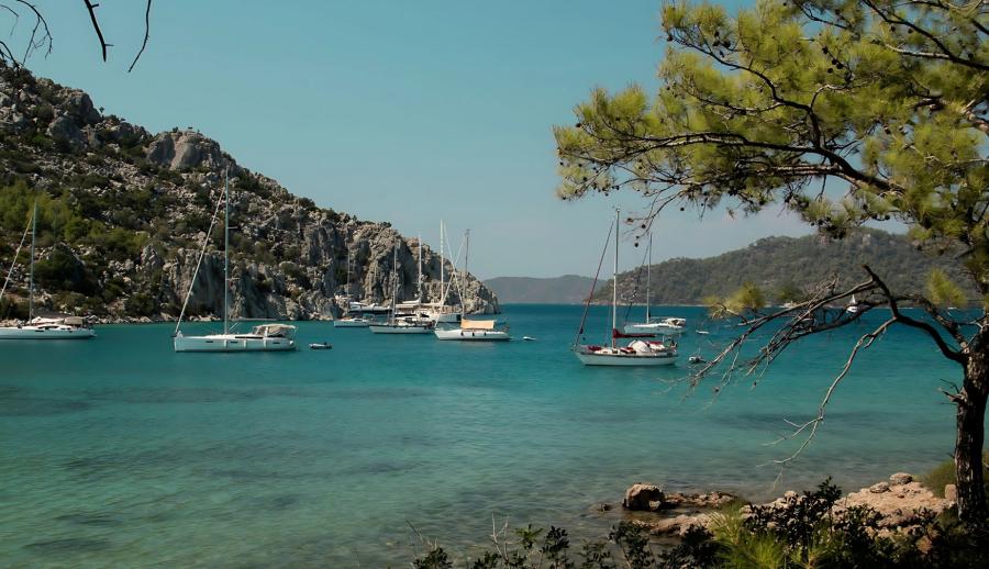 Ankara Çıkışlı Marmaris Datça Gökova Yüzme ve Tekne Turu (2 Gece Otel Konaklamalı) : Ege’nin mahzun çocuğu, tatillerin vazgeçilmezi… Marmaris…Tepeden bakıldığında beyaz elbisesinin eteklerini savuran, saçlarına rengarenk begonviller takmış, bilekleri misket limon kokan alımlı bir kıza benzeyen belde… 
